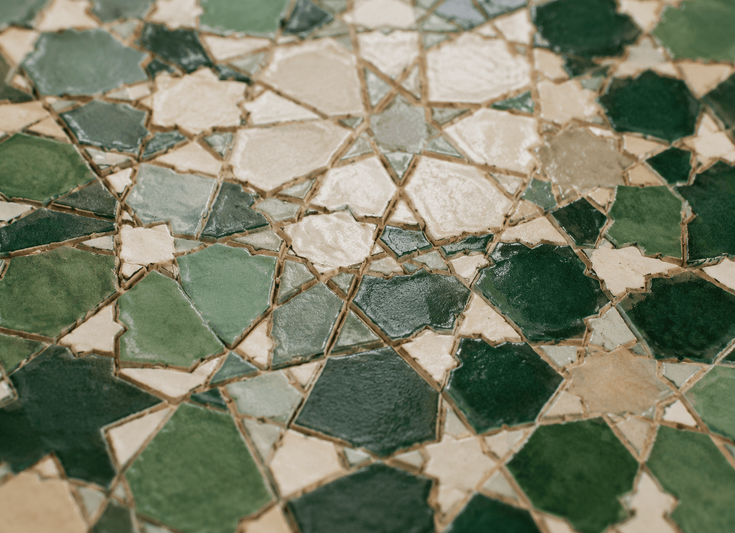 Mosaïque de zellige en étoile, verte et crème, vue de près